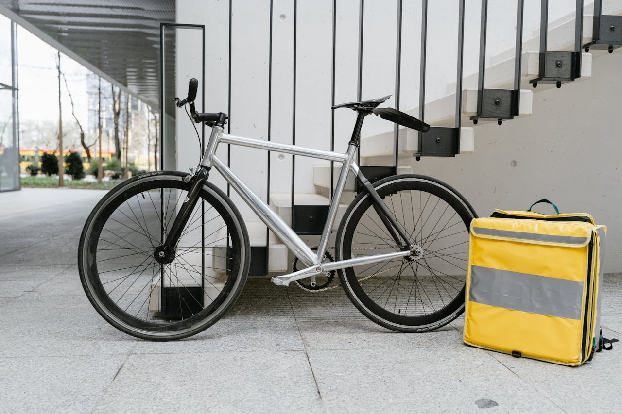 A bicycle with a delivery bag poised for service in a modern urban environment.